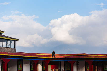 Man tourist sit on the roof in evening of Rumtek Monastery in winter near Gangtok. Sikkim, India.のeditorial素材