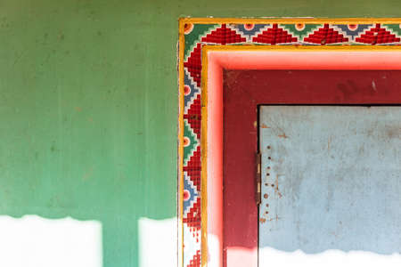 Tibetan decoration wall with green, red and yellow color with sunlight of Guru Rinpoche Temple at Namchi. Sikkim, India.の写真素材