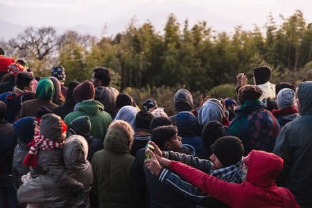 Crowded people are waiting for the first light in the dawn of new year's day with trees in background at Tiger Hill, Darjeeling. India.のeditorial素材