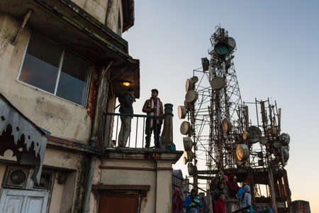 Tourists in the building are seeing the the first light in the dawn of new year's day from second floor with antenna posts from window at Tiger Hill, Darjeeling. India.のeditorial素材