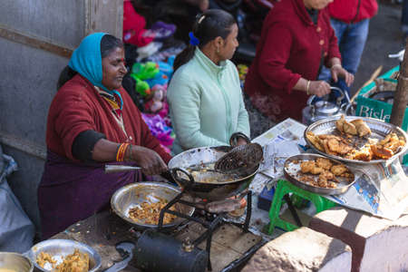 Indian woman merchant selling fried banana in the market near Tiger Hill in winter at Darjeeling, India.のeditorial素材