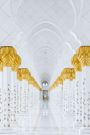 Decorated marble columns on the top with like golden palm in corridor without people inside Sheikh Zayed Grand Mosque in the morning at Abu Dhabi, UAE.のeditorial素材