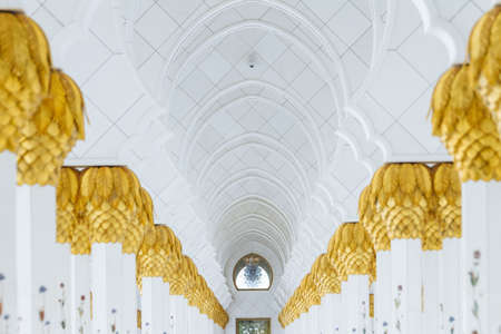 Decorated marble columns on the top with like golden palm in corridor without people inside Sheikh Zayed Grand Mosque in the morning at Abu Dhabi, UAE.のeditorial素材