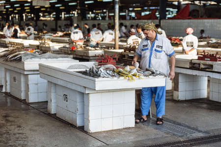 Fishmonger in semi-outdoor, open air seafood market near Palm Deira metro station in Dubai.のeditorial素材