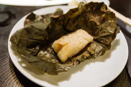 Dim Sum: Sticky rice with shrimp and wrap with lotus leaves in bamboo basket at the restaurant in Dubai.の写真素材