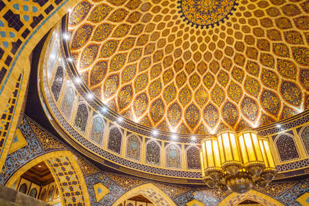 Close-up detail of the dome ceiling with yellow, brown and blue tiles decorated in Arabic style that hang with old Arabic lamp at department store in Dubai.のeditorial素材