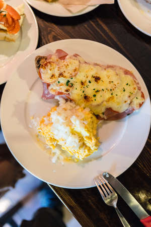 Scramble egg served with sliced baguette topping with bacon and cheese at the restaurant in Chiang Mai, Thailand.の写真素材