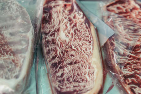 Close-up raw wagyu beef with marble texture wrap in clear plastic sealed in Bangkok, Thailand.の写真素材
