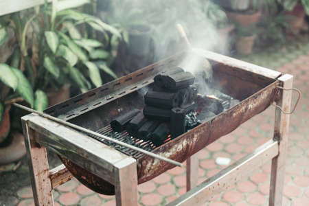 Pile of charcoal over the fire, smoke are coming and charcoal are burning on stove in Bangkok, Thailand.の写真素材