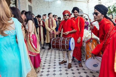 Musicians band wearing red Bandhgala and black Pheta at Indian wedding ceremony in Bangkok,...