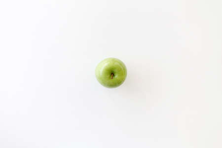 Top view of Left hand grab a green apple on white background.の写真素材