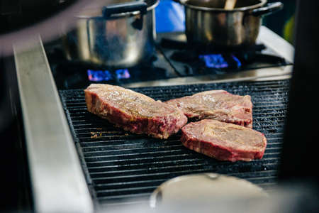 Marinated raw wagyu beef cuts from left to right: T-Bone Steak, Rib Eye and Top Loin Steak grilled...