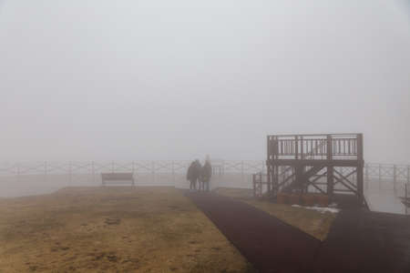 Tourists stand in the fog at observation area on the top of Mount Usu in winter in Hokkaido, Japan.の写真素材