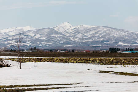 Close up Mount Yotei (inactive stratovolcano) with village on the foot hill and snow cover on the ground in winter in Hokkaido, Japan.の写真素材
