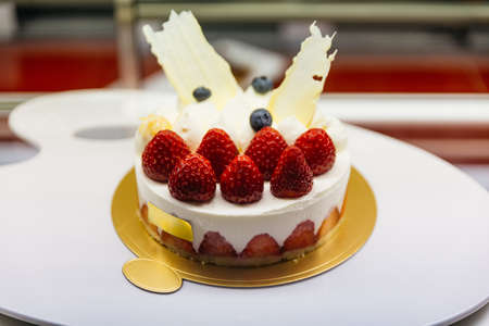 Strawberry shortcake cheesecake on golden paper with many fresh red strawberry at cafe in Otaru, Hokkaido, Japan.の写真素材