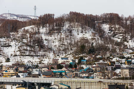 Cityscape with snow mountain in the background in winter in Hokkaido, Japan.