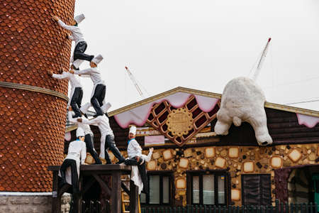 Chef sculptures connect with the others to lean the sloped building and climbing white bear at...