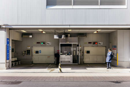 Front of hi-tech car park building with guard at Sapporo in Hokkaido, Japan.のeditorial素材