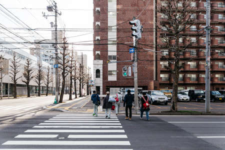 Sapporo cityscape with buildings, road, cars and walking people in Hokkaido, Japan.のeditorial素材