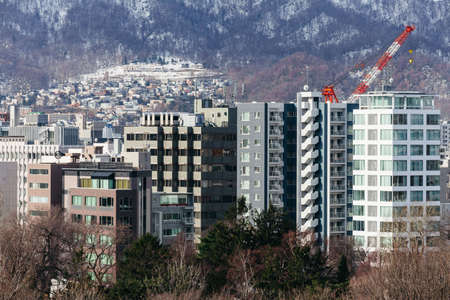 Sapporo cityscape with buildings and mountain in the background in Hokkaido, Japan.のeditorial素材