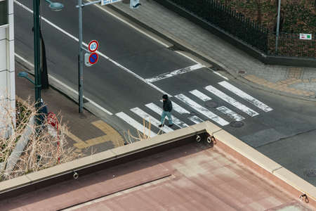Man cross the road by crosswalk that view from above in the morning in Sapporo, Hokkaido, Japan.の写真素材