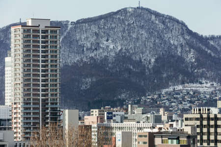 Sapporo cityscape with buildings and mountain in the background in Hokkaido, Japan.のeditorial素材