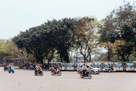 Street of Hanoi with trees and moving motorcycles on the road in Vietnam.のeditorial素材