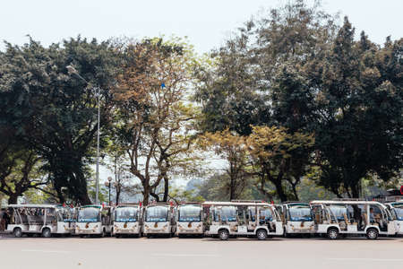 Street with trees and pull over Vietnamese tuk tuks on the road in Hanoi, Vietnam.のeditorial素材