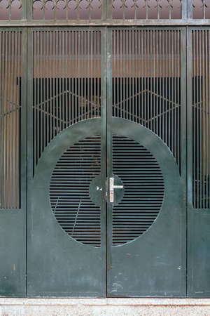 Dark green steel door with line and circle form in Hanoi, Vietnam.の写真素材