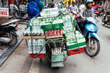 Motorcycle carry many water bottles packs on the back seat in Hanoi, Vietnam.のeditorial素材