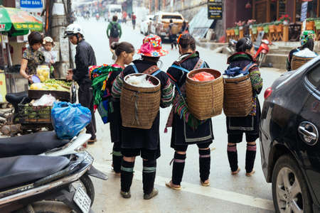 Mountaineers carry basket and stand on the road at market in summer in Sa Pa, Vietnam.のeditorial素材