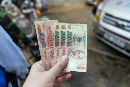 Vietnamese banknotes in left hand waiting for pay in Sa Pa, Vietnam.の写真素材
