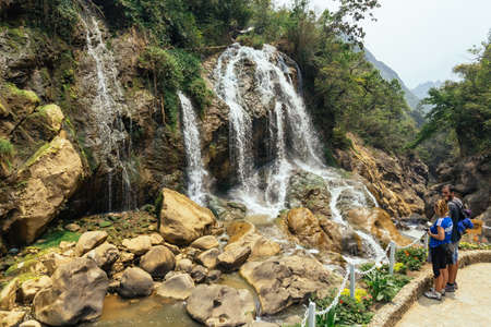 Couple tourists looking Waterfall with river flow with rocks in summer at Cat Cat Village in summer in Sa Pa, Vietnam.のeditorial素材