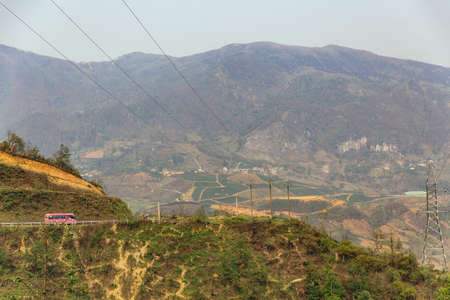 Landscape with electric posts and trees with pink color bus on the left side in summer in Sa Pa, Vietnam.の写真素材