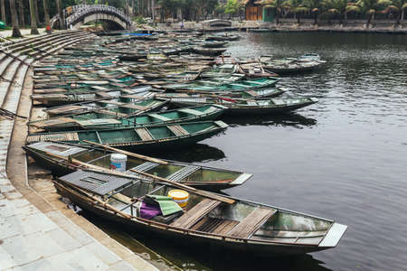 Boat stop on the river with many empty row boats in summer at Trang An Grottoes in Ninh Binh, Vietnam.のeditorial素材