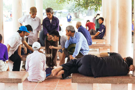 People play Xiangqi ( Chinese Chess) with audiences on the land in the area of Trang An Grottoes in summer at Ninh Binh, Vietnam.のeditorial素材