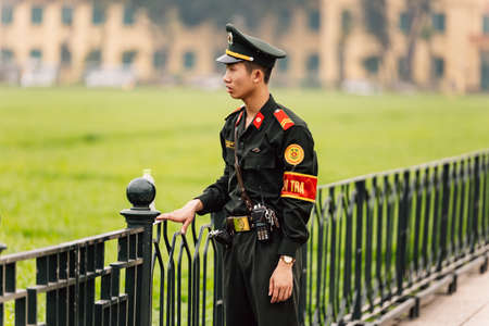 Vietnamese police officer standing on the green field in front of Ho Chi Minh Mausoleum at Hanoi, Vietnam.のeditorial素材