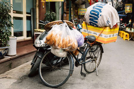 Empty bicycle carry baguette and stuff for sell parking at street of Hanoi, Vietnam.のeditorial素材