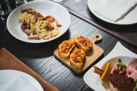 Side dish is Canape, grilled bread topping with sauce made by dice tomato and bell pepper.の写真素材