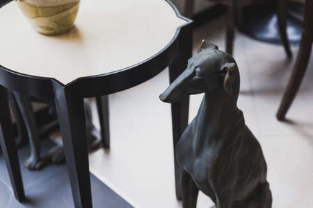 Close up black greyhound sculpture that sit near low table.の写真素材