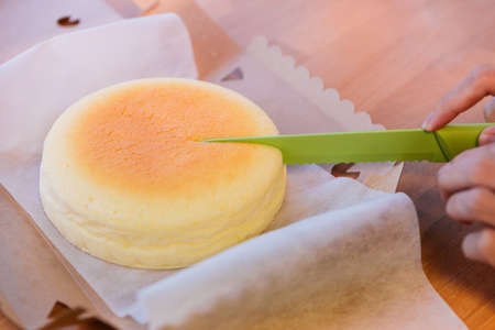 Japanese Cheesecake cut by green knife in opened paper box. Soft and sweet.の写真素材