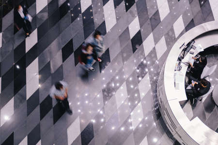 People are walking on the rectangle pattern floor. With circle counter on the right.のeditorial素材
