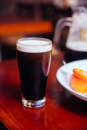 (Black Beer) in glass on wooden table in the bar.