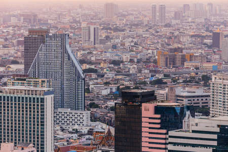 Aerial view of Bangkok modern office buildings, condominium in Bangkok city downtown at the dusk. With golden and purple sky.の写真素材