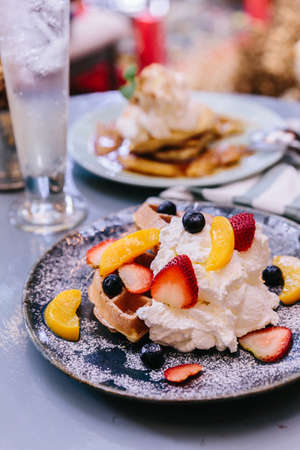 Fresh baked Pancakes topping with strawberry, orange, blueberry and whip cream.の写真素材