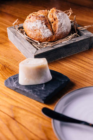 Creative Fine Dinning: Fresh baked bread on straw in wooden box served with homemade butter.