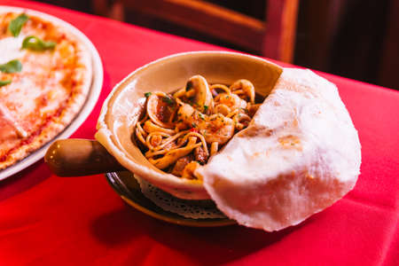 Napoli Spaghetti including shrimp, clam and squid that covered with pizza dough.