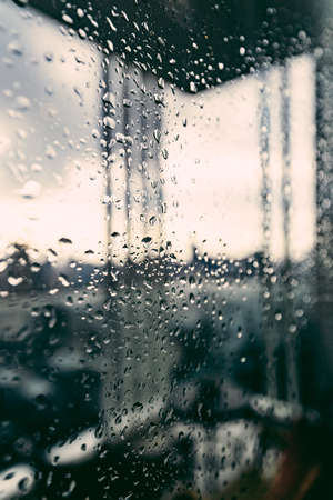 Rain over Bangkok: Cityscape behind the window glass with rain drops
