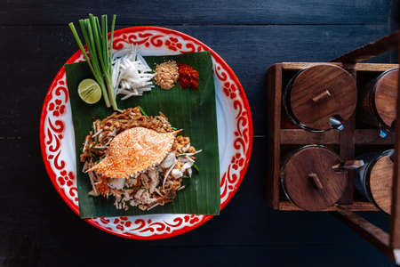 Crab Pad Thai served with lime, scallions, bean sprouts. crushed peanut and chili powder.