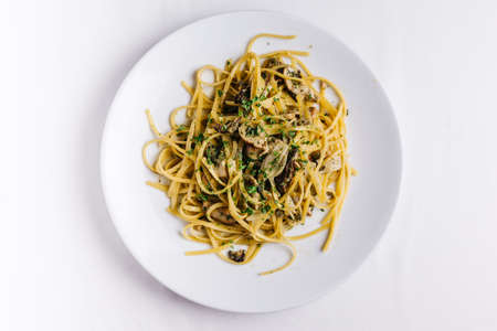 Top view of Oyster spaghetti served in white plate on white tablecloth.の写真素材
